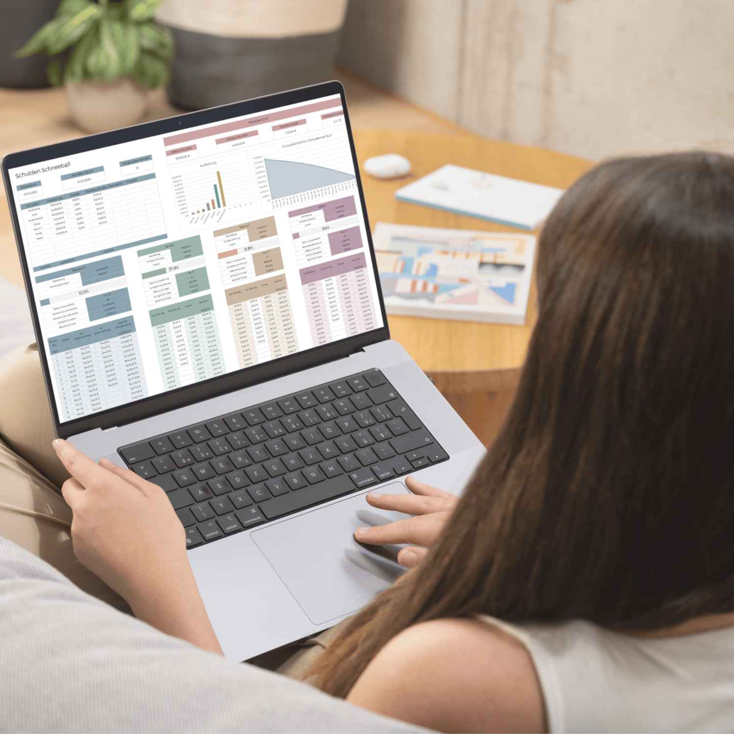 Frau arbeitet mit der Schulden Schneeball Excel-Vorlage auf einem Laptop und behält Tilgungsplan, Restschuld und Schuldenverlauf im Blick.